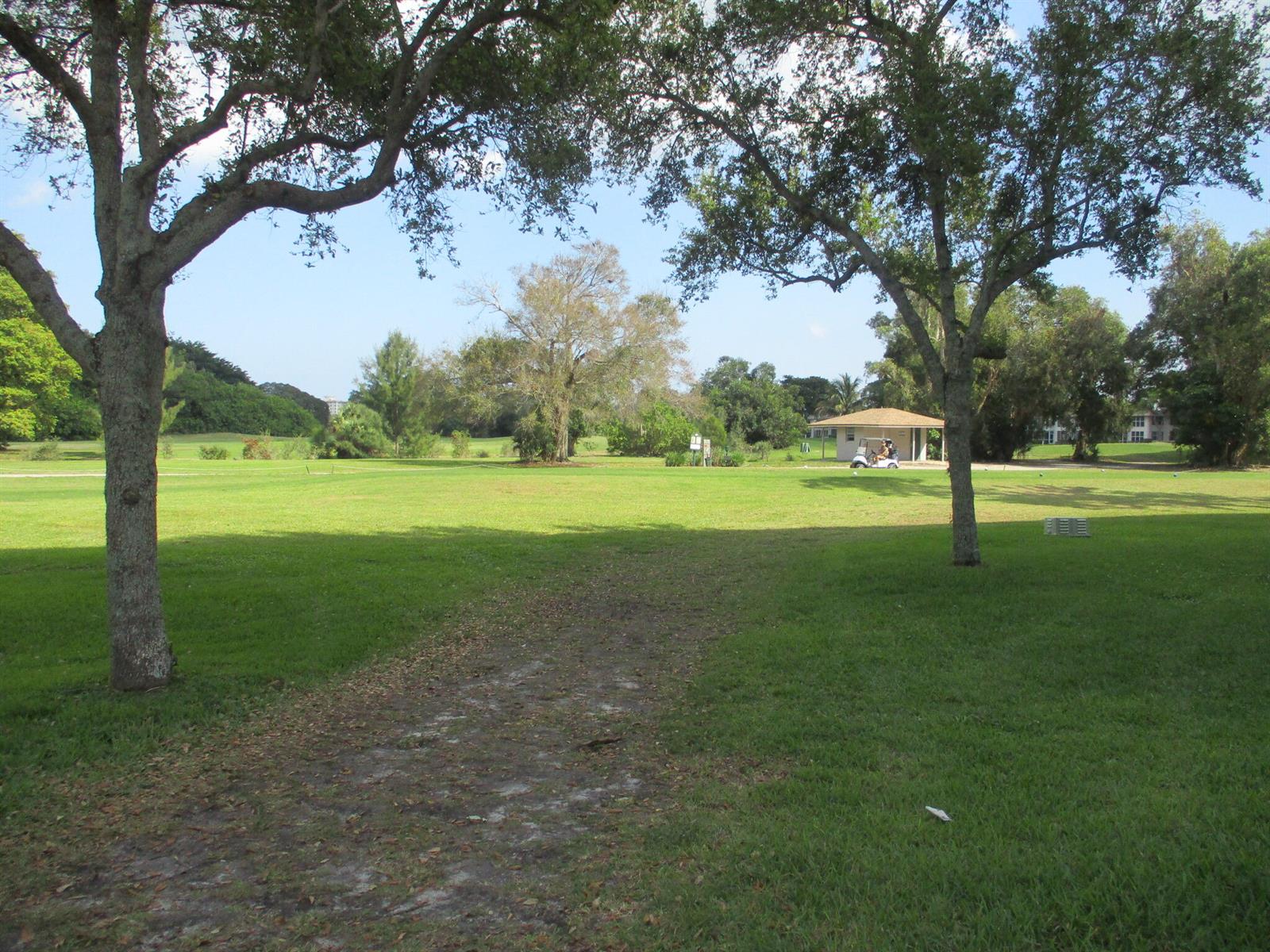 A golf course fairway is framed by two large trees with a small building nearby — 3300 N Palm Aire Drive # 306, Pompano Beach FL 33069, POMPANO BEACH, FL
