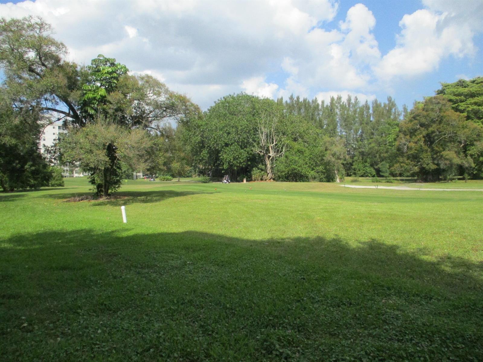 A wide, grassy golf course fairway is framed by mature trees under a cloudy sky — 3300 N Palm Aire Drive # 306, Pompano Beach FL 33069, POMPANO BEACH, FL