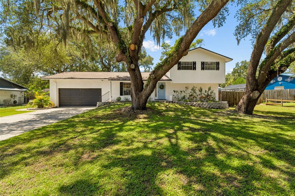 A two-story white house with a garage and large oak trees in the front yard — 114 WINDY CIRCLE, BRANDON, FL
