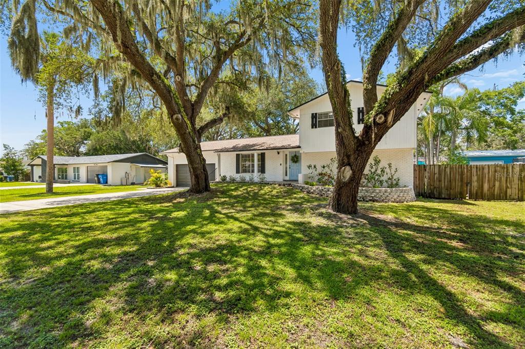 A two-story house with a white exterior and large oak trees in the front yard — 114 WINDY CIRCLE, BRANDON, FL