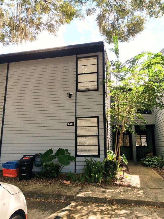 A two-story gray house with black trim, a small front yard, and a concrete walkway — 4419 SW 20TH LANE, GAINESVILLE, FL