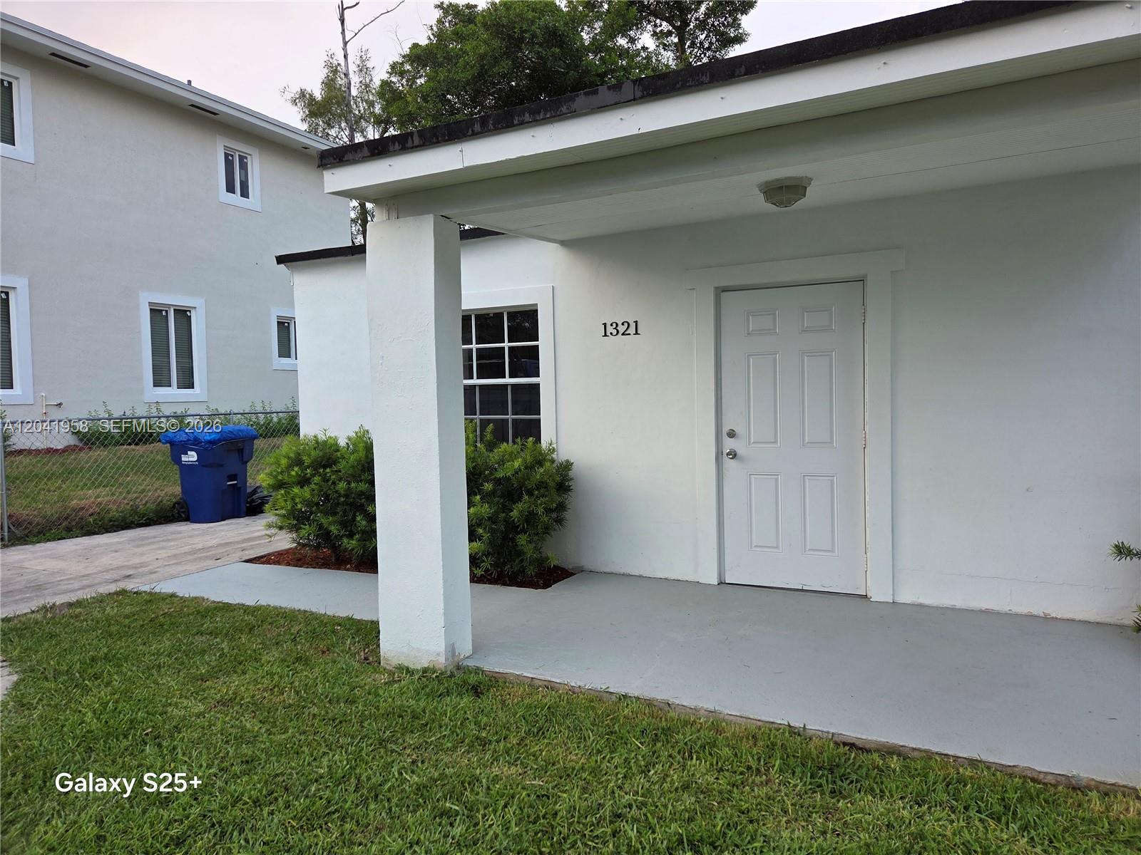 A white house exterior features a covered porch, a front door, and a small window — 1321 NW 82nd St, Miami FL 33147, MIAMI, FL