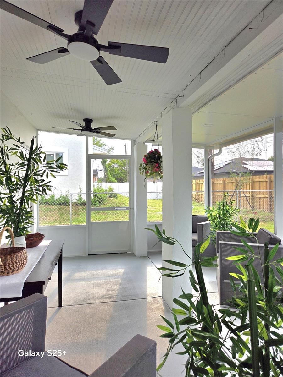 A screened-in porch features a concrete floor, two ceiling fans, and views of a backyard — 1321 NW 82nd St, Miami FL 33147, MIAMI, FL