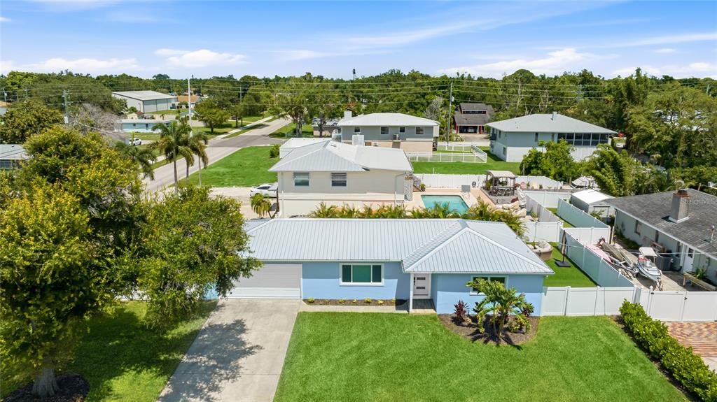 An aerial view shows a light blue house with a metal roof and a pool — 912 21ST AVENUE W, PALMETTO, FL