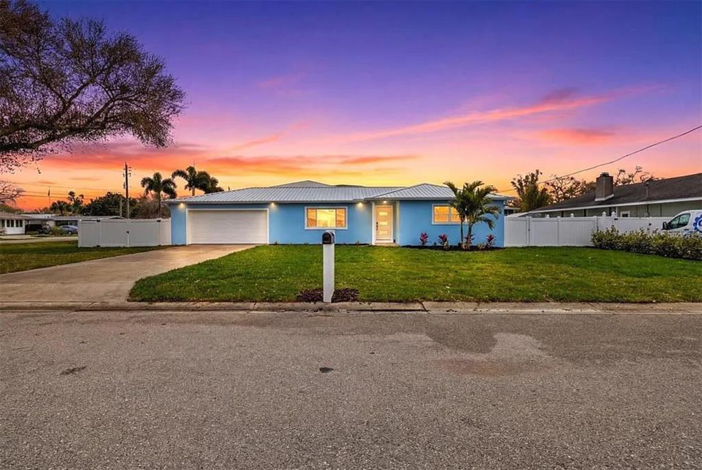 A light blue single-story house with a white garage door and a metal roof — 912 21ST AVENUE W, PALMETTO, FL
