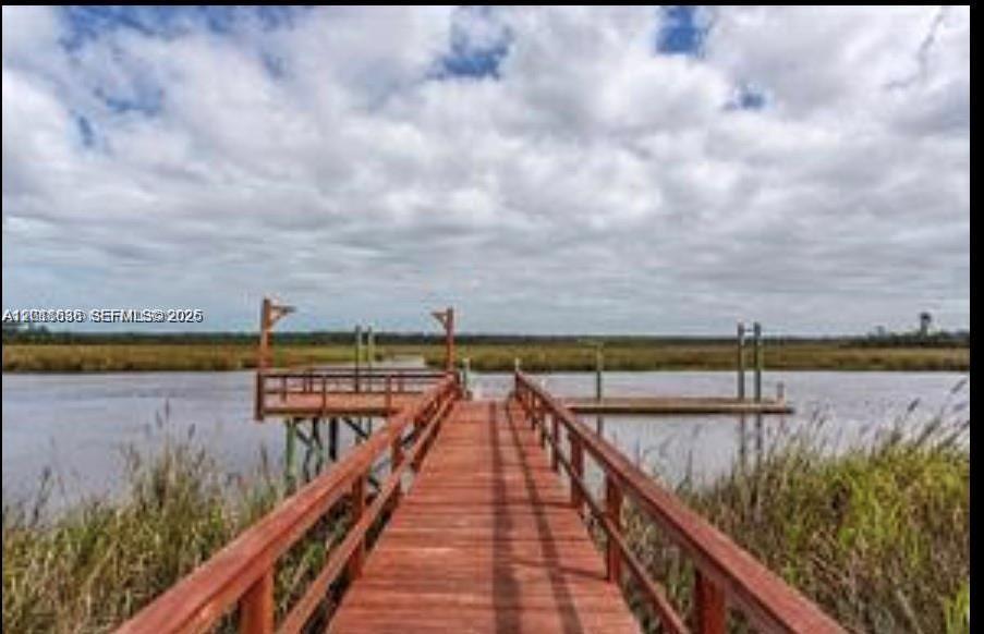 A wooden pier extends over a calm waterway toward a grassy marsh under a cloudy sky — Lot 59 Magnolia Plantation, GA 31568, GA