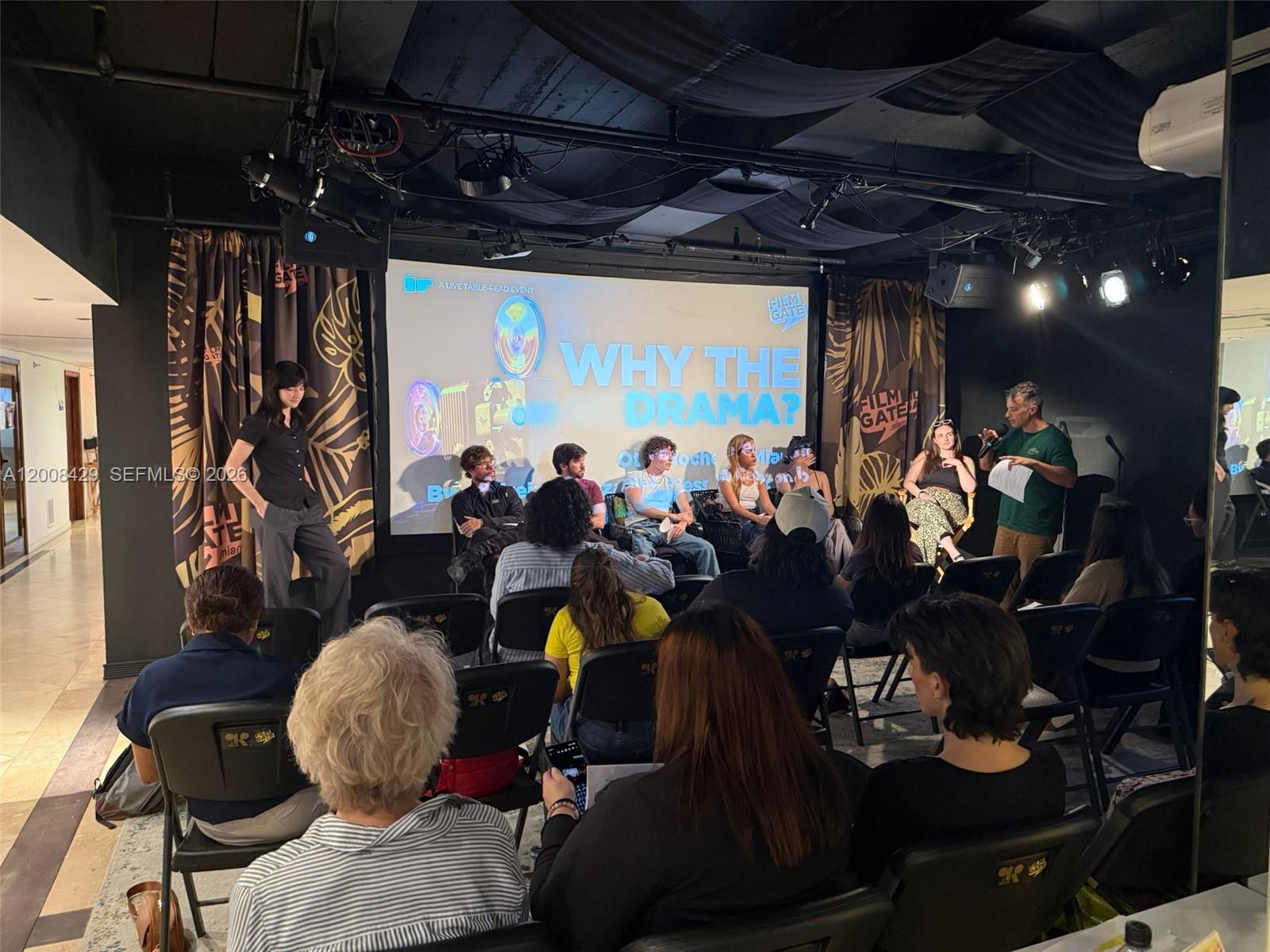 A group of people sit on a stage for a panel discussion in a theater — 168 SE 1st St # 400, Miami FL 33131, MIAMI, FL