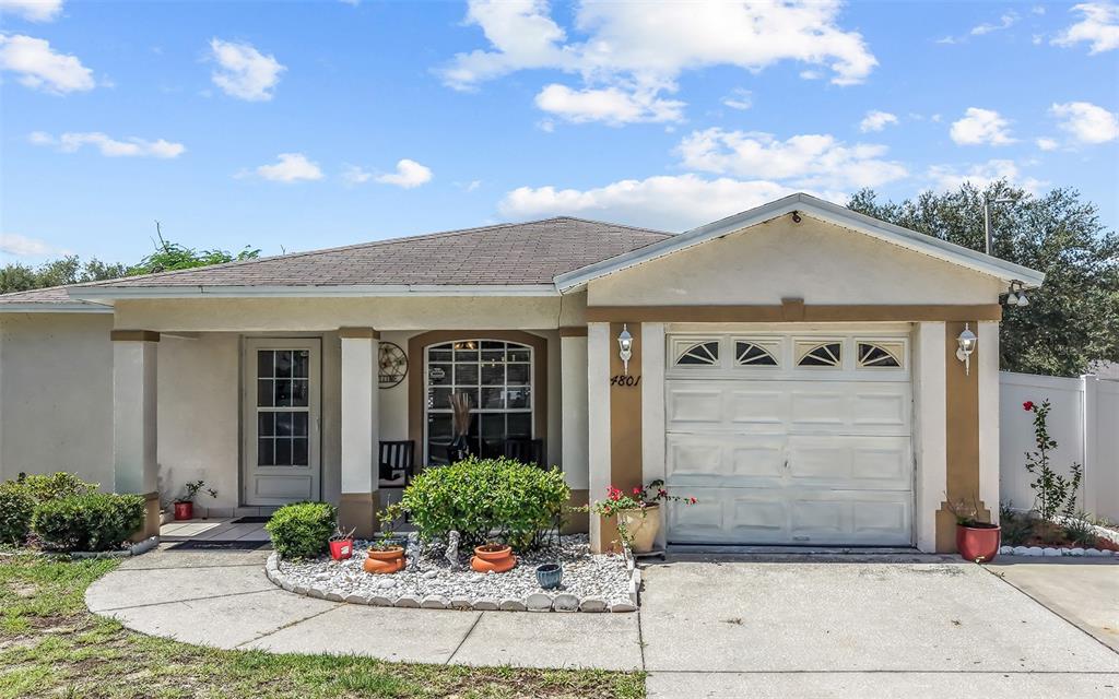 A single-story house features a white stucco exterior, a front porch, and an attached garage — 4801 ROCK FISH COURT, TAMPA, FL