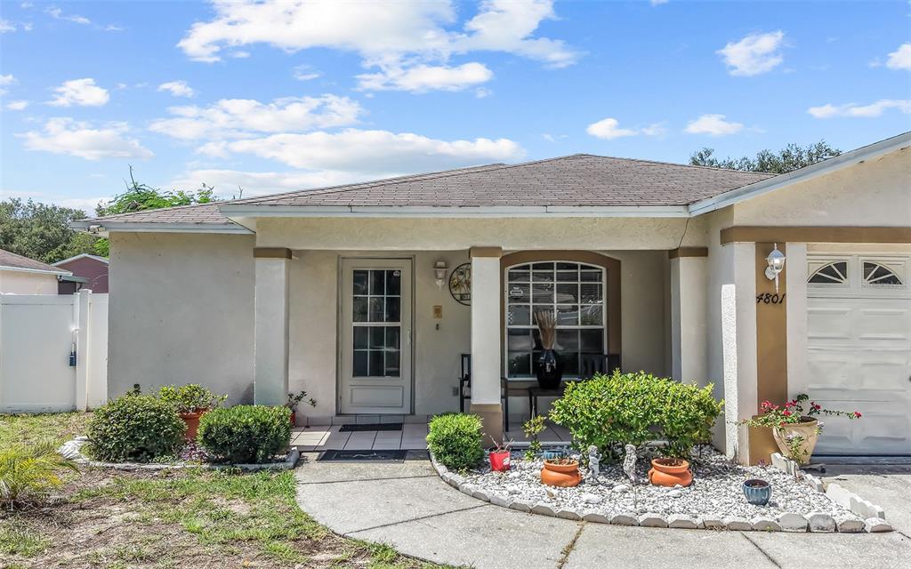 A single-story house with a white stucco exterior, a covered entryway, and a garage — 4801 ROCK FISH COURT, TAMPA, FL
