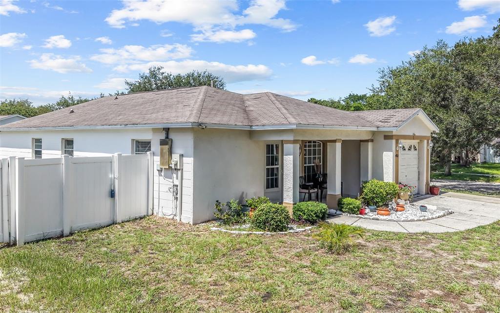 A single-story house with a white exterior, a covered entryway, and a white privacy fence — 4801 ROCK FISH COURT, TAMPA, FL