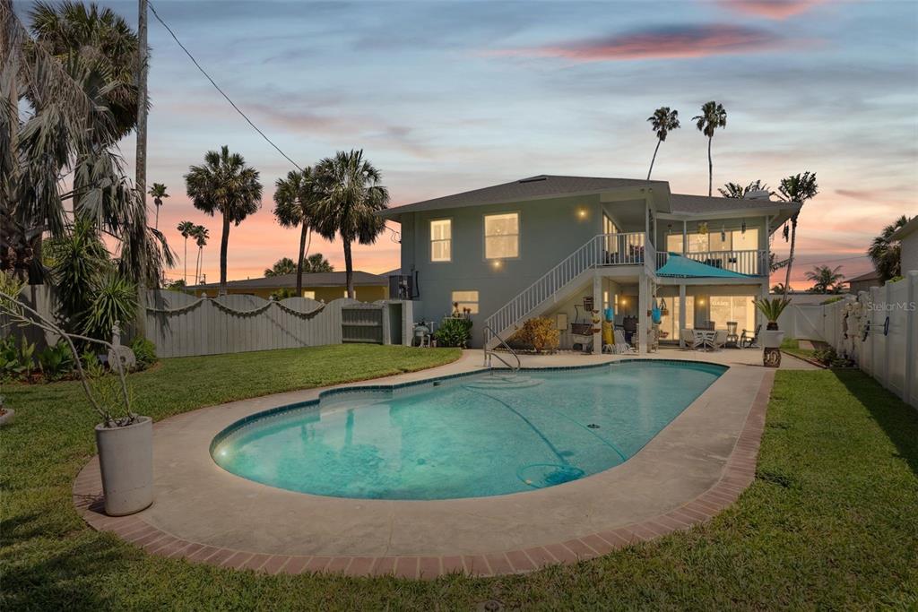 A two-story house with a backyard swimming pool, a wooden fence, and palm trees — 1842 BAYOU GRANDE BOULEVARD NE, ST PETERSBURG, FL