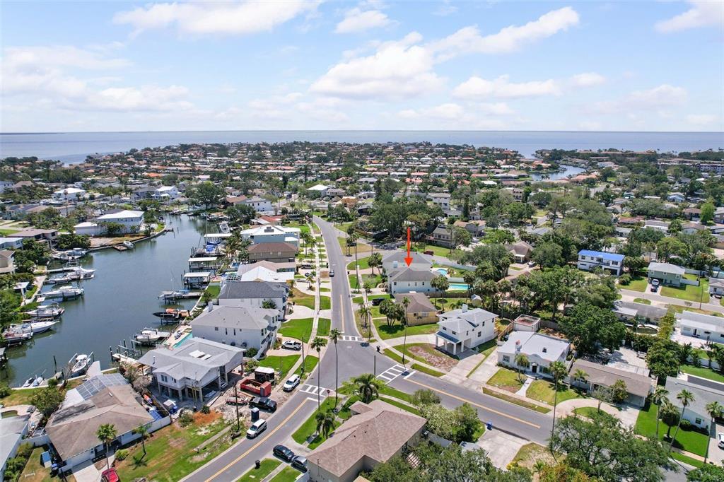 An aerial view shows a residential neighborhood with a canal, houses, and a red arrow — 1842 BAYOU GRANDE BOULEVARD NE, ST PETERSBURG, FL