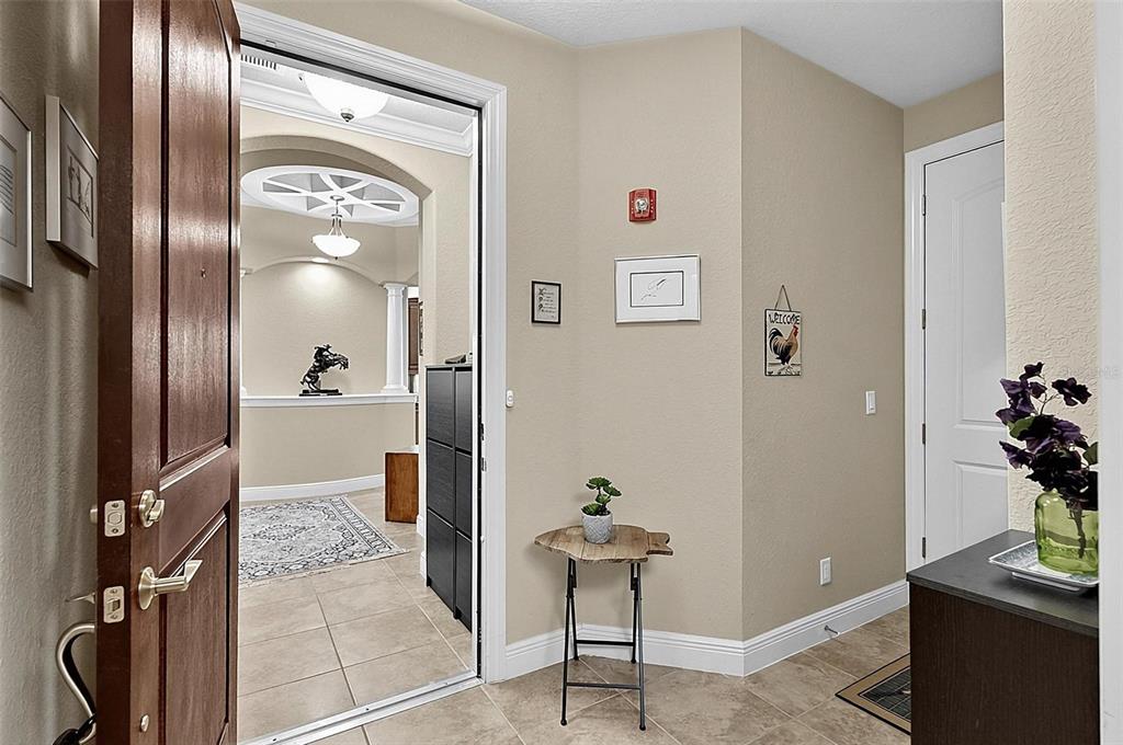 An entryway with tile flooring leads into a living area featuring a decorative ceiling medallion — 200 CEDAR COVE UNIT 205, PALM COAST, FL