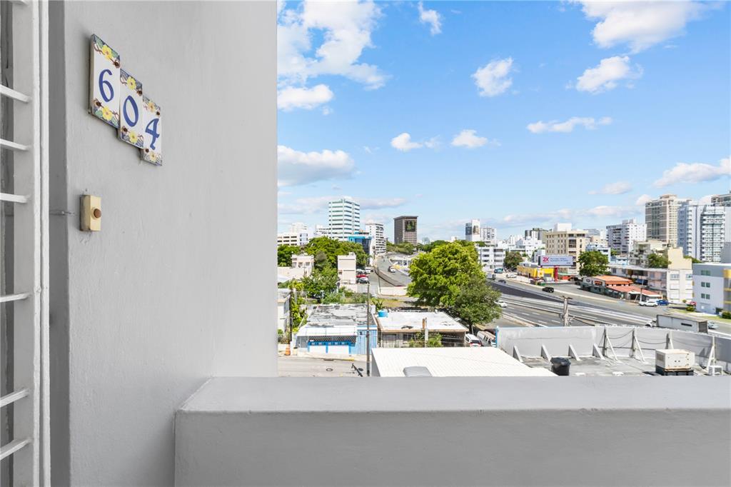 A view from a balcony showing a building number sign and a city streetscape — 212 DIEZ DE ANDINO UNIT 604, SAN JUAN, PR