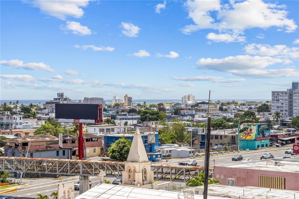 An elevated view shows a city street, a church steeple, and the distant ocean — 212 DIEZ DE ANDINO UNIT 604, SAN JUAN, PR