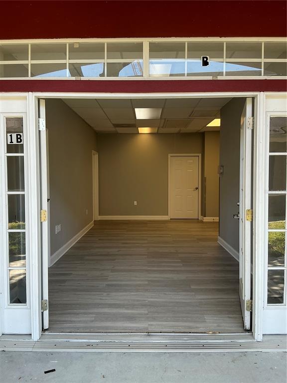 An open office space with gray walls, wood-look flooring, and a drop ceiling — 11701 ORPINGTON STREET UNIT 1B, ORLANDO, FL