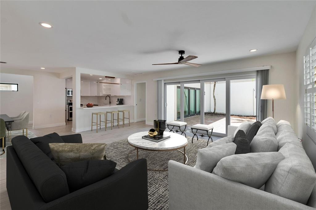 A living room with a white sofa, black armchair, marble coffee table, and open kitchen — 370 S WOODLANDS DRIVE, OLDSMAR, FL