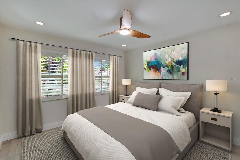 This is a virtually staged bedroom featuring a gray upholstered bed, ceiling fan, and window curtains — 370 S WOODLANDS DRIVE, OLDSMAR, FL