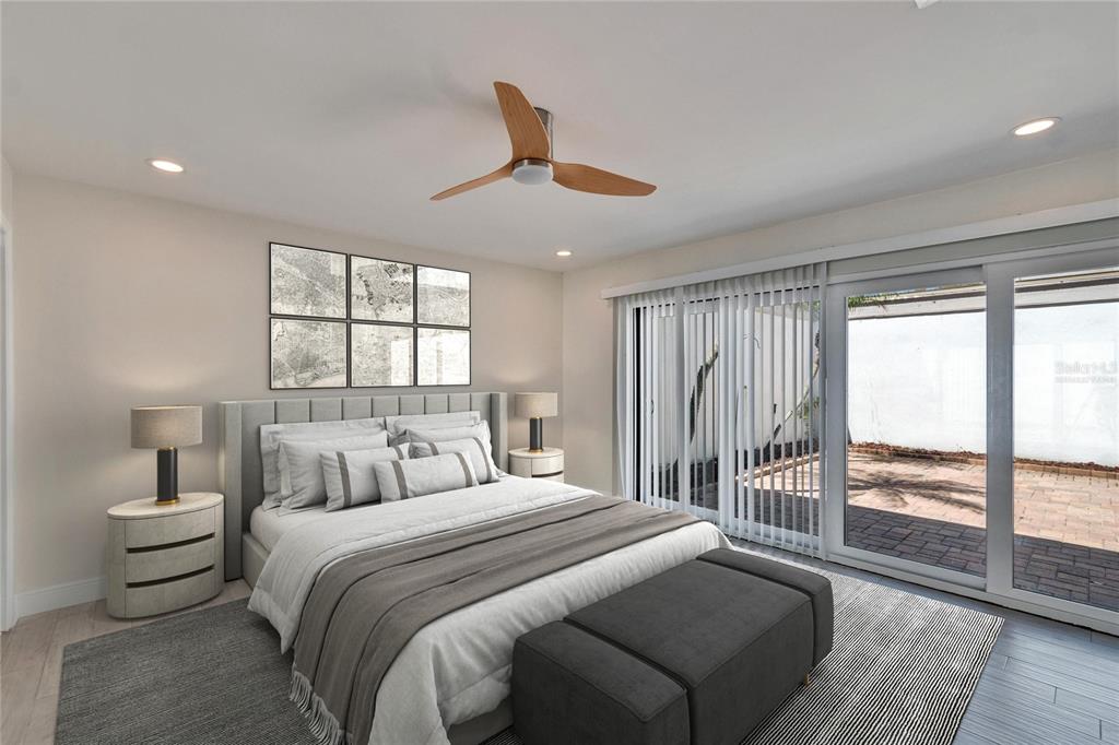 A modern bedroom features a gray upholstered bed, a ceiling fan, and sliding glass doors — 370 S WOODLANDS DRIVE, OLDSMAR, FL