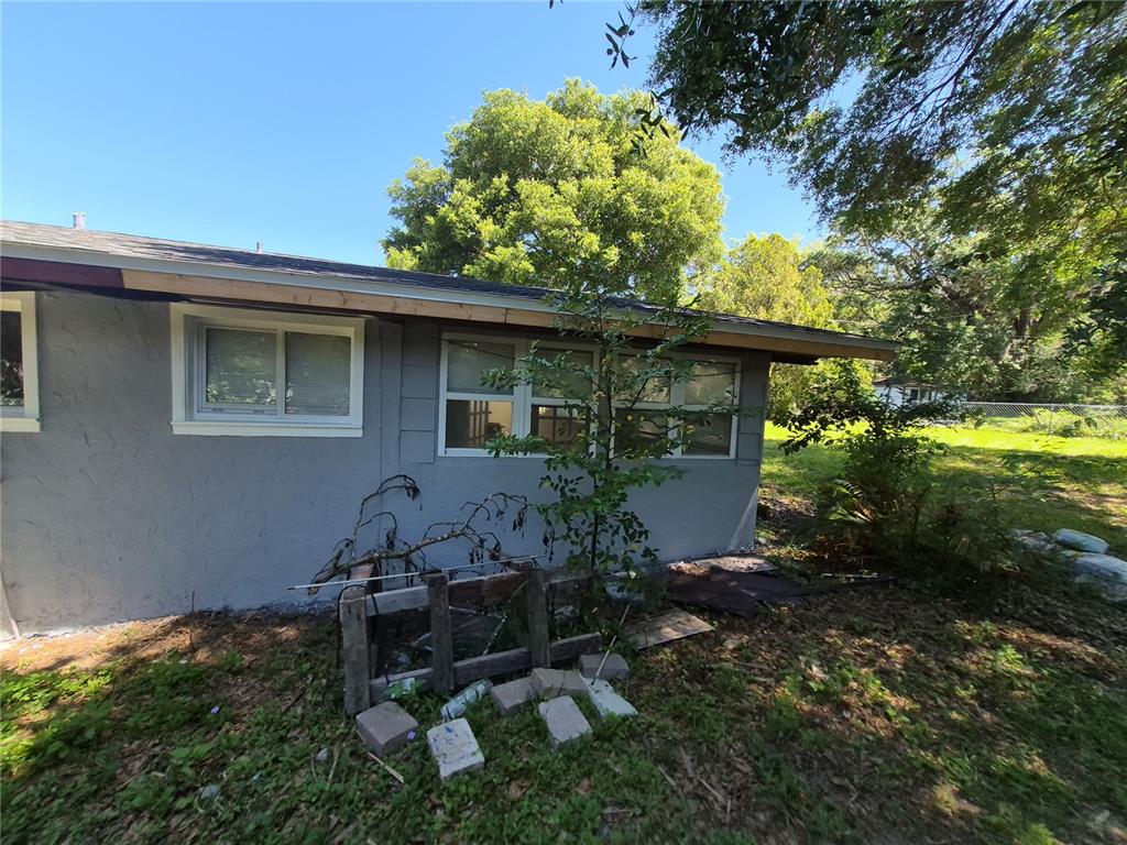 The exterior of a gray house features a partially finished wooden fascia board and windows — 6500 SE 25TH AVENUE, OCALA, FL