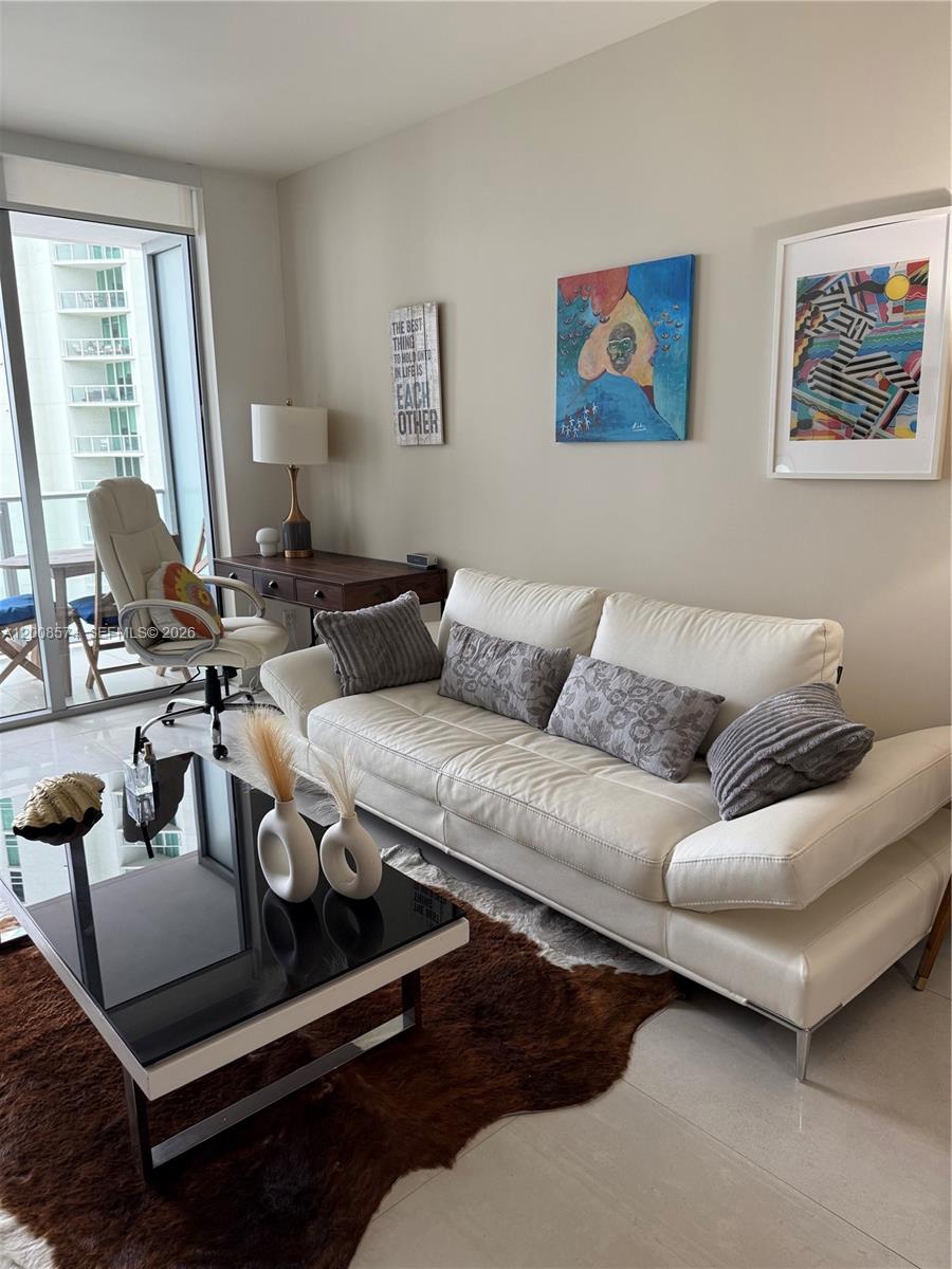 A living room features a white leather sofa, a glass coffee table, and an office desk — 1300 Brickell Bay Dr # 807, Miami FL 33131, MIAMI, FL