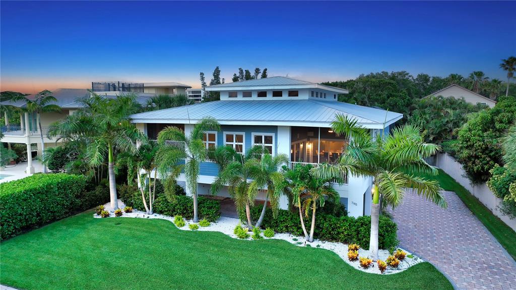 A two-story house with a metal roof, screened porch, and palm trees in the yard — 1145 HORIZON VIEW DRIVE, SARASOTA, FL