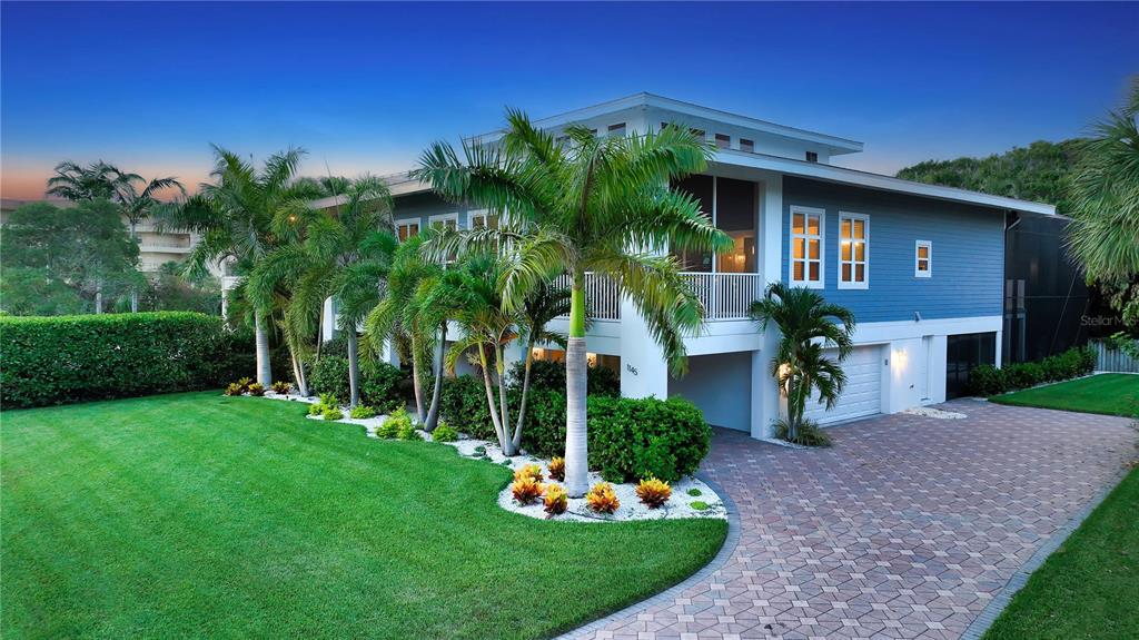 A two-story blue house with a paved driveway, palm trees, and a manicured lawn — 1145 HORIZON VIEW DRIVE, SARASOTA, FL
