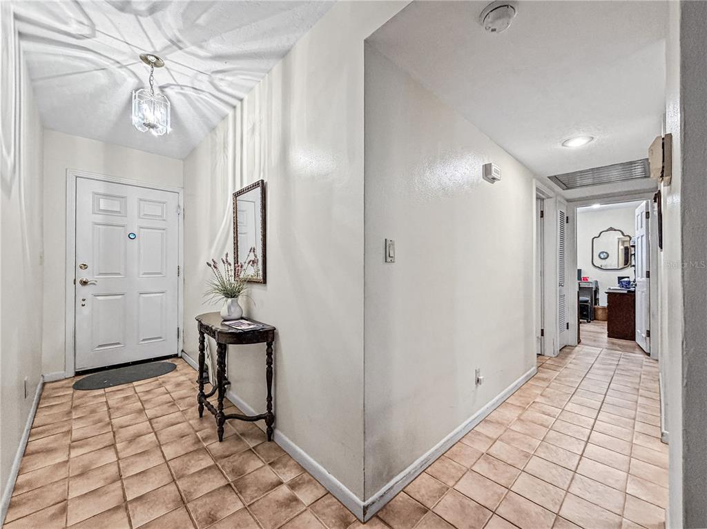 An entryway features a tiled floor, a white front door, and a hallway leading inward — 2340 DERBYSHIRE ROAD, MAITLAND, FL