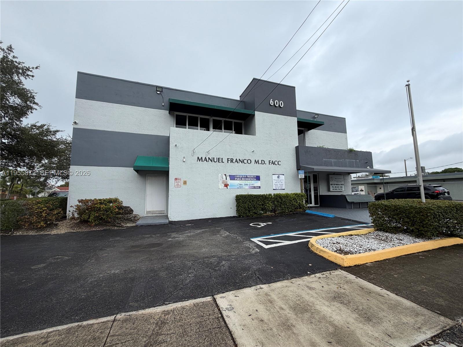 A two-story commercial building with gray and white horizontal stripes and a paved parking lot — 600 NW 35th Ave # 201, Miami FL 33125, MIAMI, FL