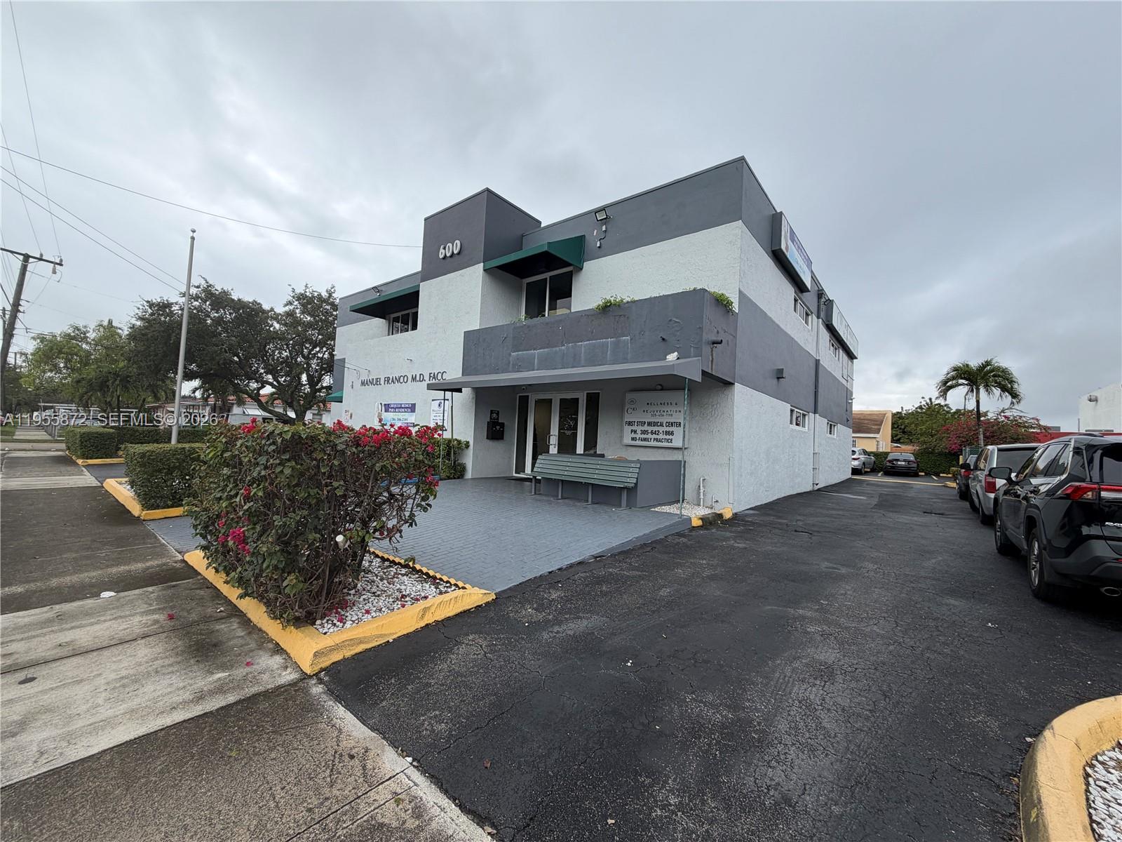 A two-story commercial building with a grey and white facade features a paved entrance area — 600 NW 35th Ave # 201, Miami FL 33125, MIAMI, FL
