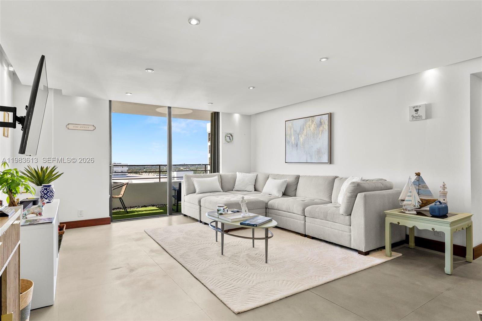 A living room features a large sectional sofa, a coffee table, and a balcony view — 2500 Parkview Dr # 2319, Hallandale Beach FL 33009, HALLANDALE BEACH, FL