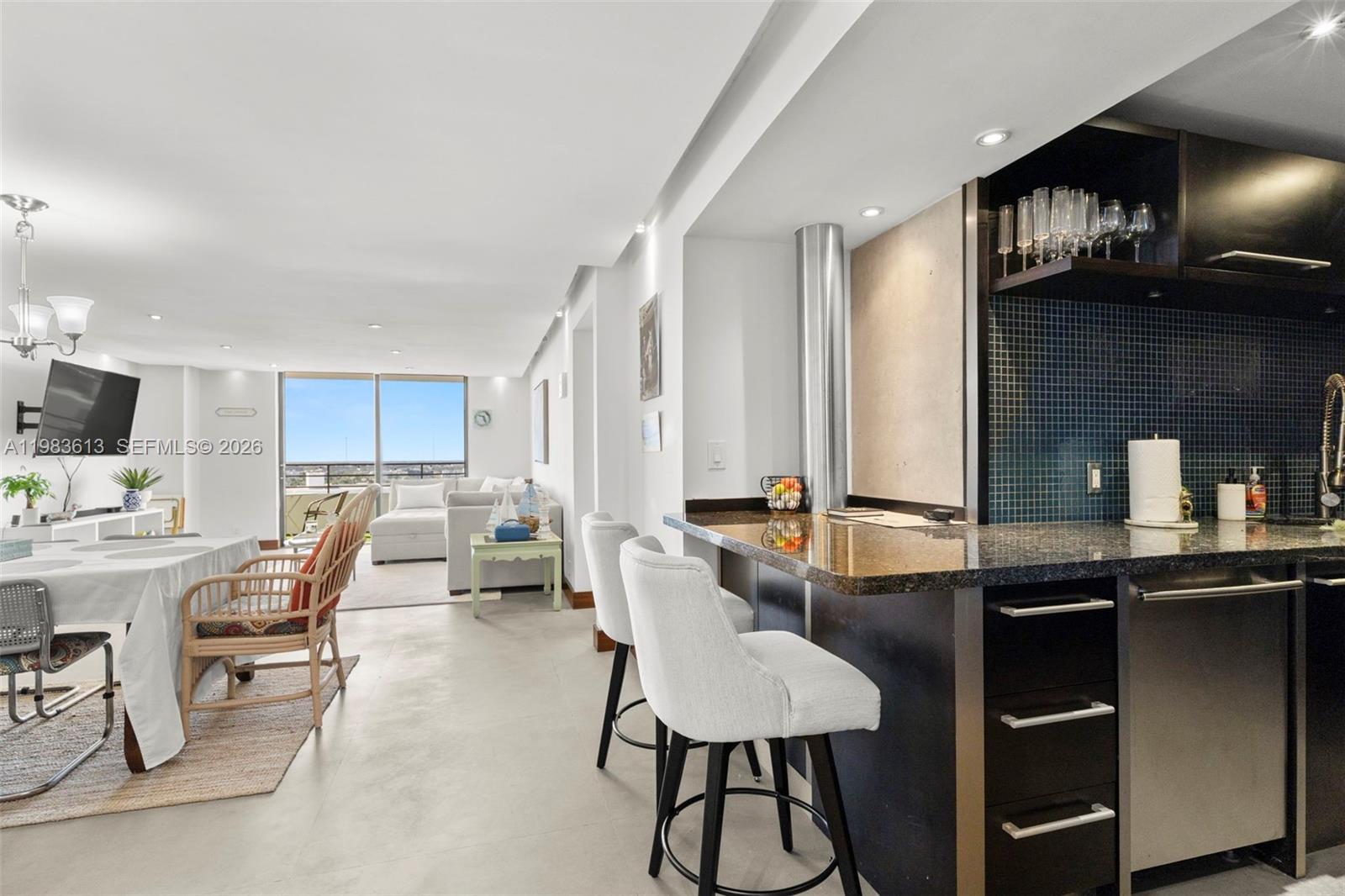An open-concept living area features a kitchen with a breakfast bar and a dining space — 2500 Parkview Dr # 2319, Hallandale Beach FL 33009, HALLANDALE BEACH, FL
