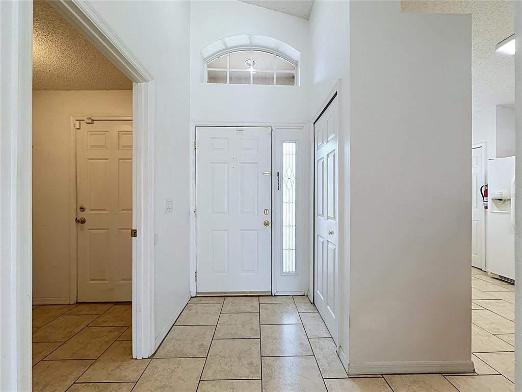 A tiled entryway features a white front door with a sidelight and a transom window — 659 DURANGO LOOP STREET, DAVENPORT, FL