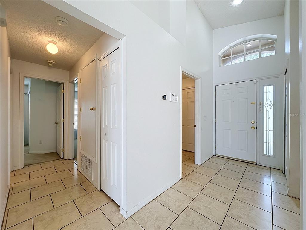 A tiled entryway features a white front door with a transom window and interior doors — 659 DURANGO LOOP STREET, DAVENPORT, FL