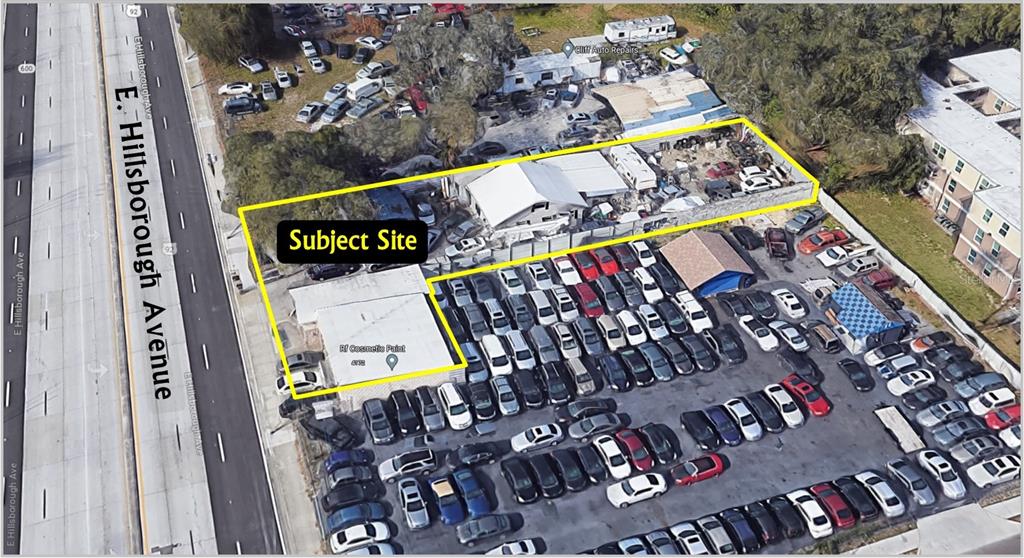 An aerial view shows a commercial property with a building and a large parking lot — 4172-4174 E HILLSBOROUGH AVENUE, TAMPA, FL