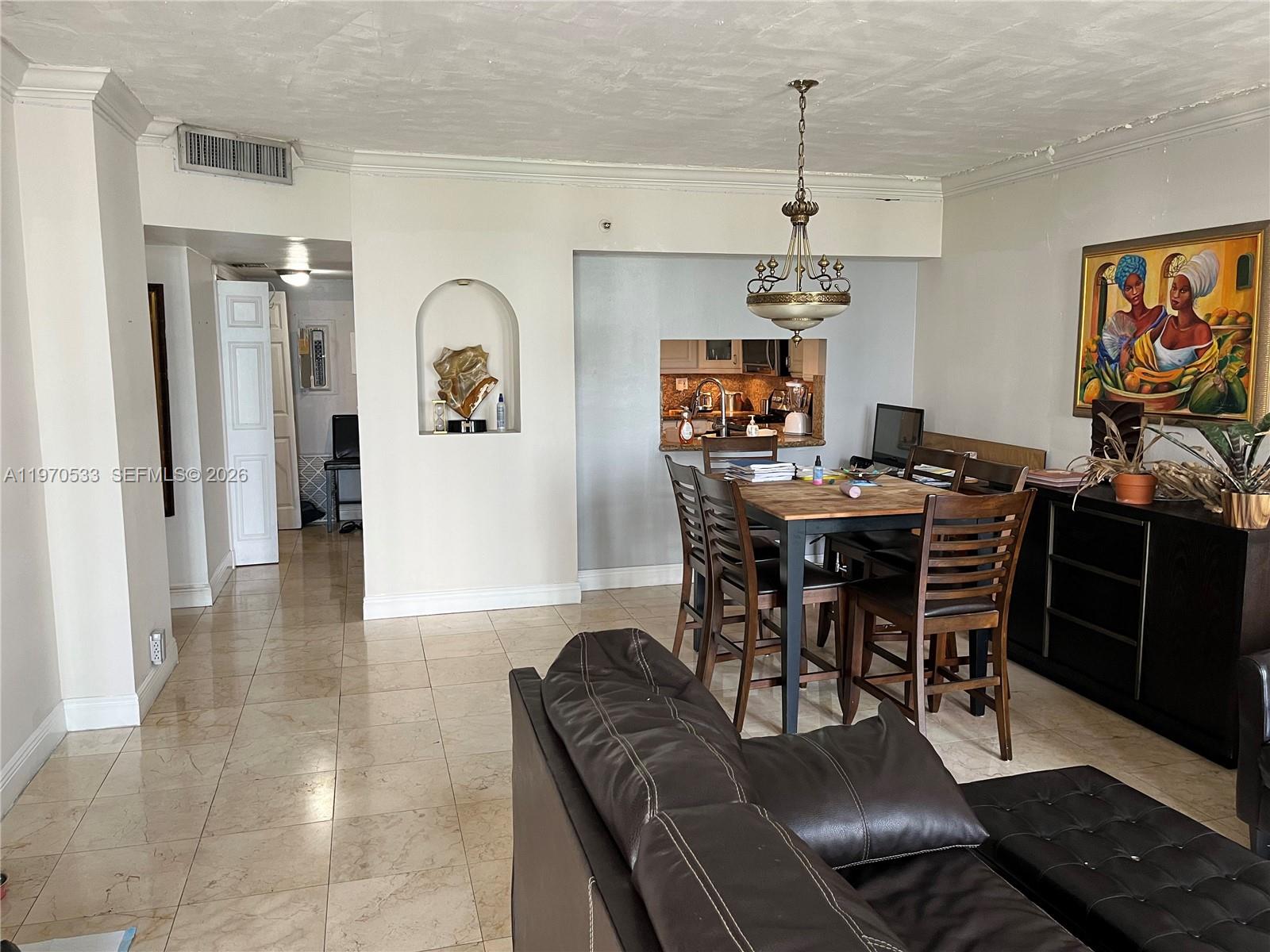 A dining area with a wooden table and chairs sits adjacent to a living room — 520 Brickell Key Dr # A610, Miami FL 33131, MIAMI, FL