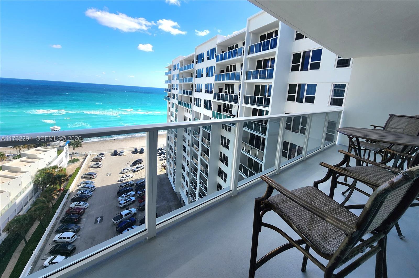 A high-rise balcony overlooks a parking lot, beach, and the ocean — 3505 S Ocean Dr # 1206, Hollywood FL 33019, HOLLYWOOD, FL