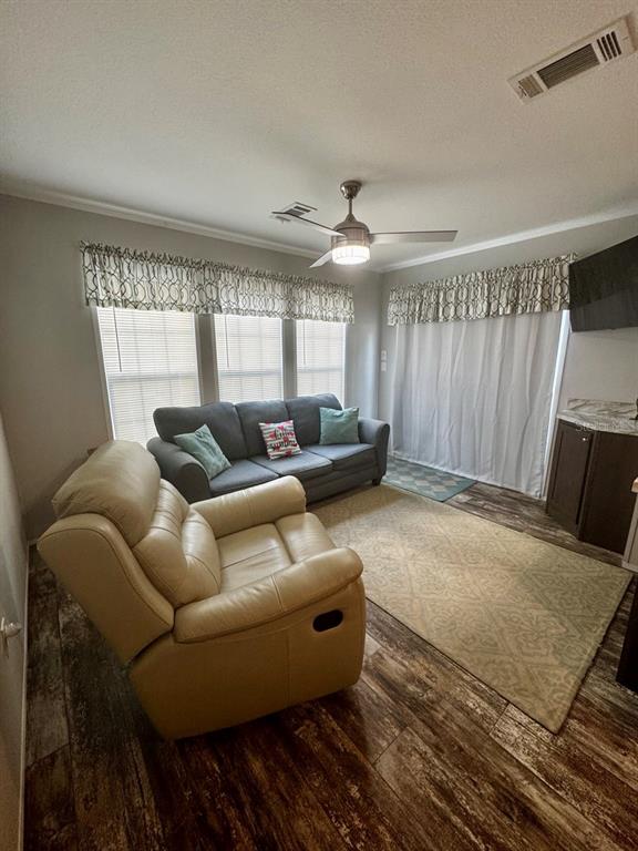A living room features a beige recliner, a gray sofa, and wood-look flooring — 14365 NE 252ND COURT ROAD UNIT 123, SALT SPRINGS, FL