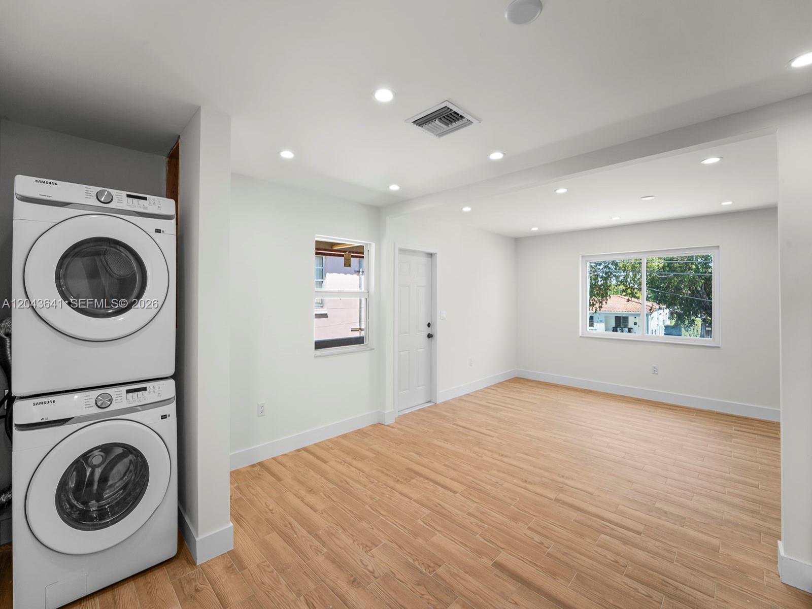 A room with light wood-look flooring, white walls, recessed lighting, and a stacked laundry unit — 238 NW 41st Ave # 0, Miami FL 33126, MIAMI, FL