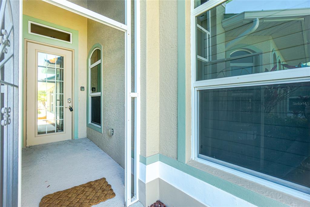 A covered entryway features a screen door, a front door with glass, and a large window — 1551 ATARES DRIVE UNIT 112, PUNTA GORDA, FL