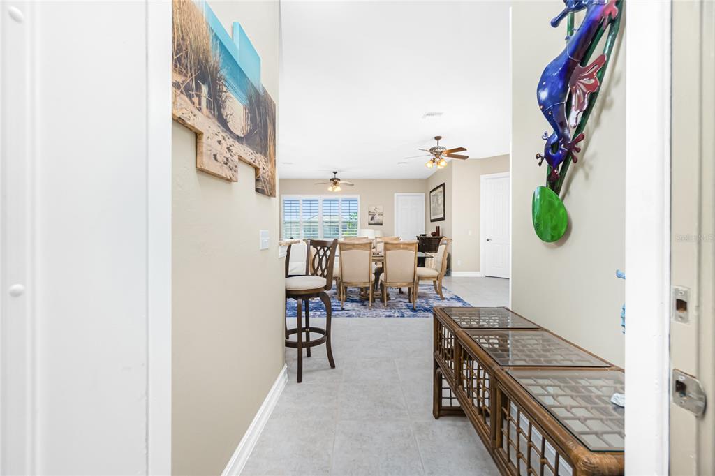 A tiled entryway leads into a dining area with a table, chairs, and bar seating — 1551 ATARES DRIVE UNIT 112, PUNTA GORDA, FL