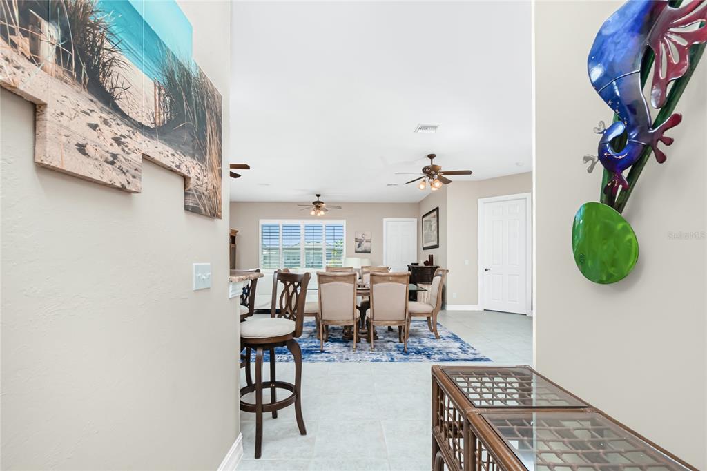 A view from a hallway looking into a dining area with a blue area rug — 1551 ATARES DRIVE UNIT 112, PUNTA GORDA, FL