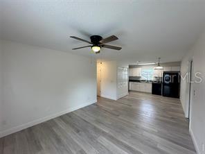 A kitchen features white cabinets, dark countertops, black appliances, and light wood-look flooring — 3717 N 56TH STREET UNIT B, TAMPA, FL