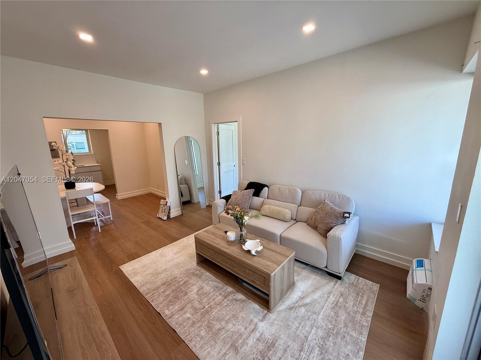 A living room features a beige sofa, a wooden coffee table, and light wood flooring — 1535 West Ave # 4, Miami Beach FL 33139, MIAMI BEACH, FL
