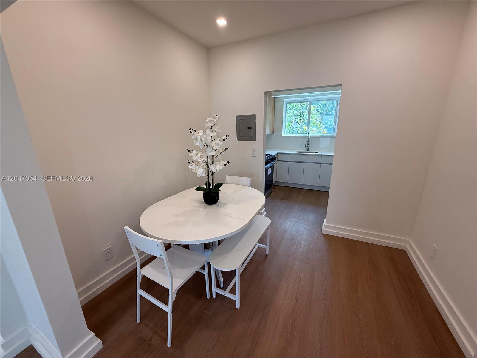 A dining area with a white oval table and chairs opens into a kitchen — 1535 West Ave # 4, Miami Beach FL 33139, MIAMI BEACH, FL