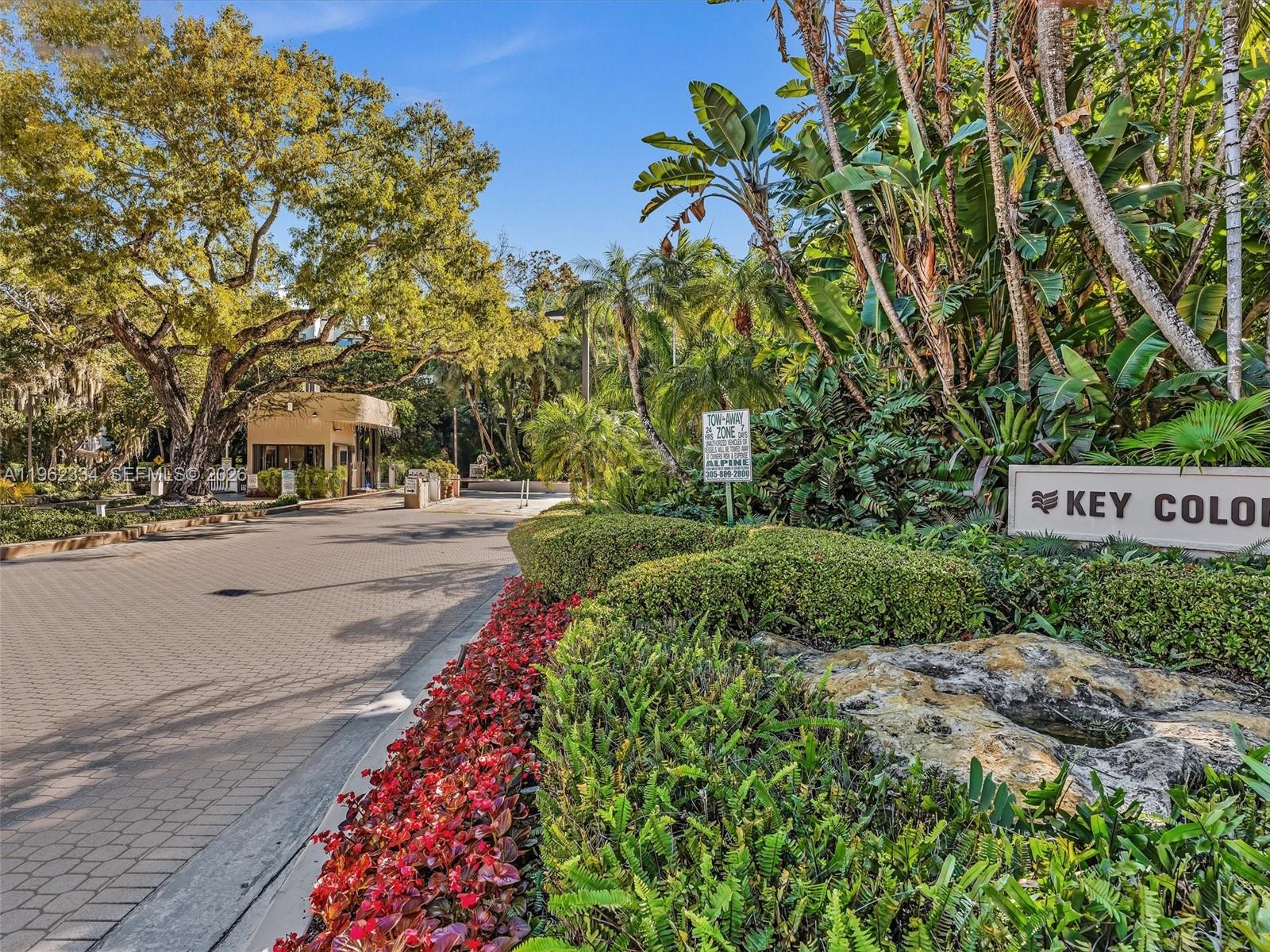 A paved driveway leads to a gated entrance surrounded by lush tropical landscaping and trees — 101 Crandon Blvd # 479, Key Biscayne FL 33149, KEY BISCAYNE, FL