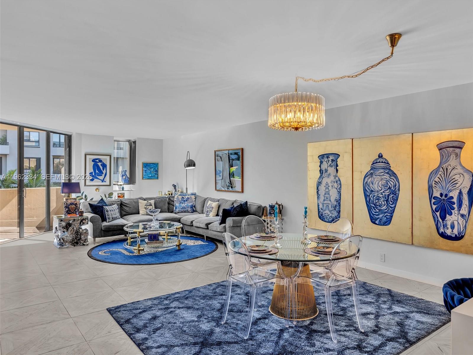 A modern living and dining room features a sectional sofa, glass tables, and blue accents — 101 Crandon Blvd # 479, Key Biscayne FL 33149, KEY BISCAYNE, FL