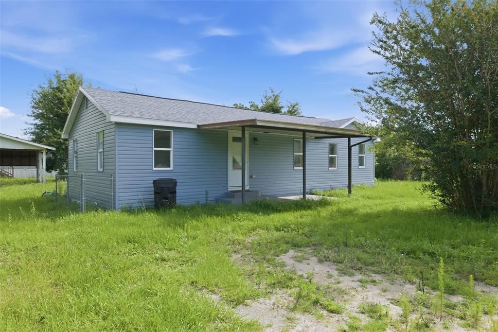 A single-story blue house with a covered front porch sits on a grassy lot — 5205 E 11TH STREET, PANAMA CITY, FL