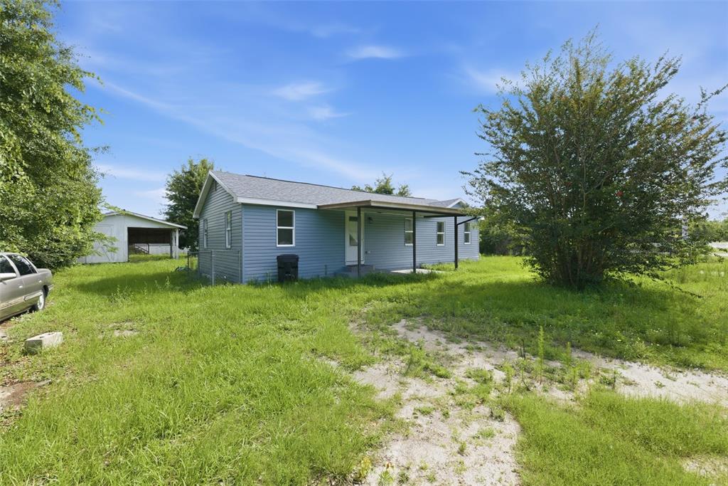 A blue single-story house with a covered porch sits on a grassy lot — 5205 E 11TH STREET, PANAMA CITY, FL