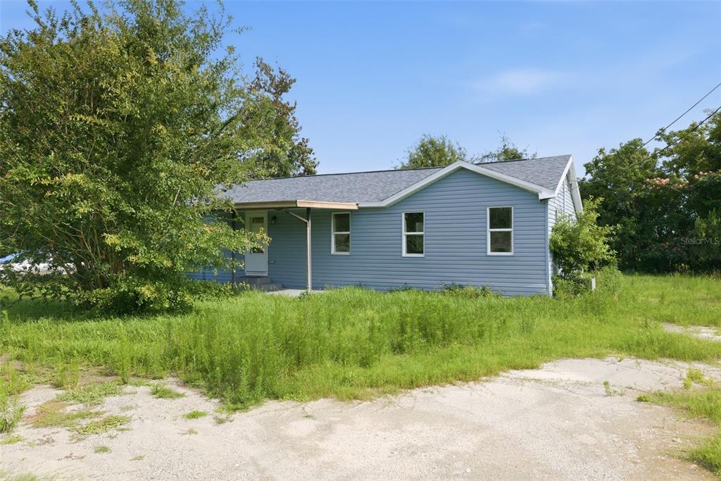 A light blue, single-story house with a covered porch sits on a grassy lot — 5205 E 11TH STREET, PANAMA CITY, FL